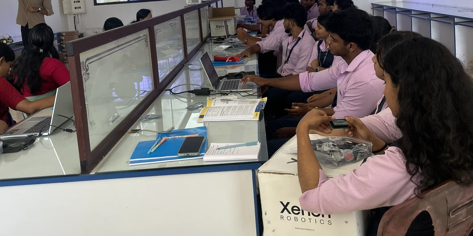 Faculty and Xenon trainers working together during a practical electronics session